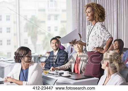 Businesswoman standing with document in hand during presentation in conference room View Large Photo Image Stock Photo - Businesswoman standing with document in hand during presentation in conference room. Fotosearch