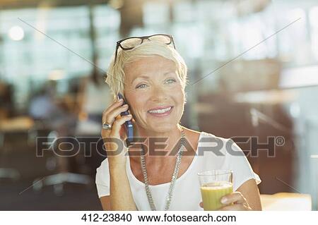 Businesswoman talking on cell phone in office View Large Photo Image Stock Image - Businesswoman talking on cell phone in office. Fotosearch