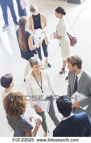 Businesswoman talking to conference participants, standing in lobby of conference center View Large Photo Image Stock Photography - Businesswoman talking to conference participants, standing in lobby of conference center. Fotosearch