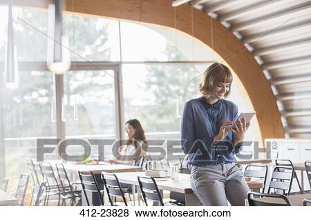 Businesswoman using digital tablet in cafeteria View Large Photo Image Stock Photo - Businesswoman using digital tablet in cafeteria. Fotosearch