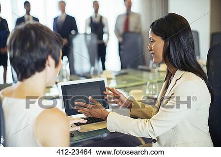 Businesswomen sitting with tablet pc in conference room View Large Photo Image Picture - Businesswomen sitting with tablet pc in conference room. Fotosearch