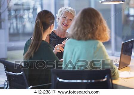 Businesswomen talking in office meeting View Large Photo Image Stock Photo - Businesswomen talking in office meeting. Fotosearch