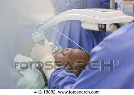 Close up of doctor wearing surgical gloves, holding oxygen mask over patient in operating theater View Large Photo Image Stock Image - Close up of doctor wearing surgical gloves, holding oxygen mask over patient in operating theater. Fotosearch