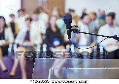 Close-up of microphone and transparent lectern with audience seen in blurred background View Large Photo Image Stock Image - Close-up of microphone and transparent lectern with audience seen in blurred background. Fotosearch