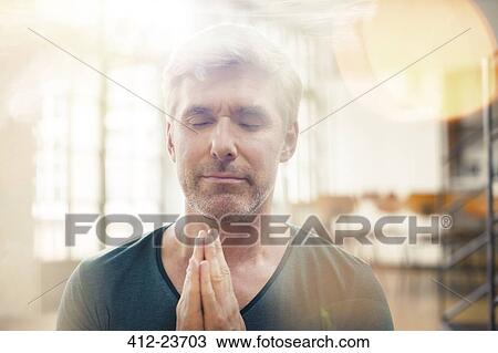 Stock Image - Close up of older man meditating. Fotosearch
