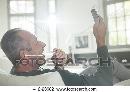 Close up of older man with earbuds talking on cell phone View Large Photo Image Stock Image - Close up of older man with earbuds talking on cell phone. Fotosearch