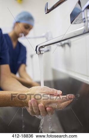Stock Photograph - Close up of surgeon hands under running water. Fotosearch