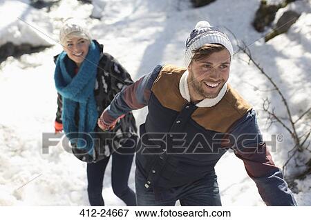 Stock Photo - Couple holding hands in snow. Fotosearch