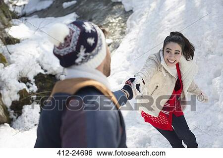 Stock Photograph - Couple holding hands in snow. Fotosearch