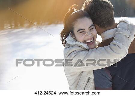 Picture - Couple hugging in snow. Fotosearch