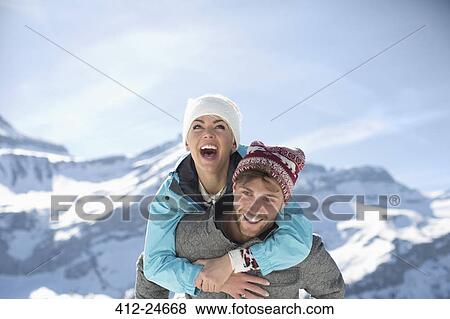 Couple piggybacking at mountains View Large Photo Image Stock Photo - Couple piggybacking at mountains. Fotosearch