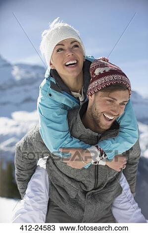 Couple piggybacking in snow View Large Photo Image Stock Image - Couple piggybacking in snow. Fotosearch