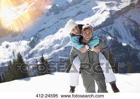 Couple piggybacking in snow View Large Photo Image Stock Photography - Couple piggybacking in snow. Fotosearch