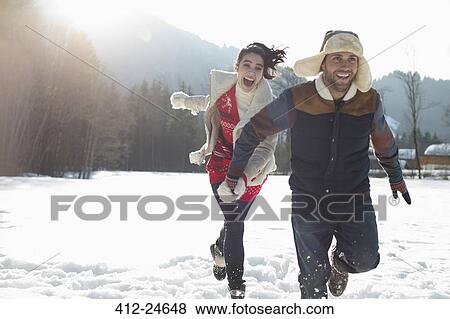 Couple running in snow View Large Photo Image Stock Photo - Couple running in snow. Fotosearch