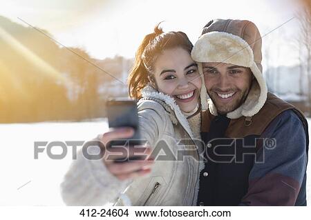Couple taking selfie in snow View Large Photo Image Picture - Couple taking selfie in snow. Fotosearch