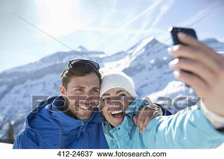 Stock Photo - Couple taking selfie in snow. Fotosearch