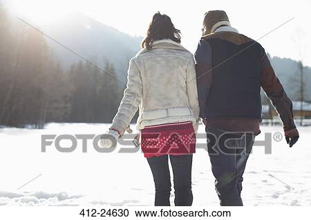 Couple walking in snow View Large Photo Image Stock Image - Couple walking in snow. Fotosearch
