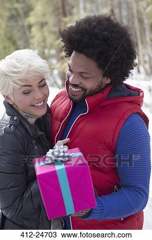 Stock Image - Couple with Christmas gift. Fotosearch