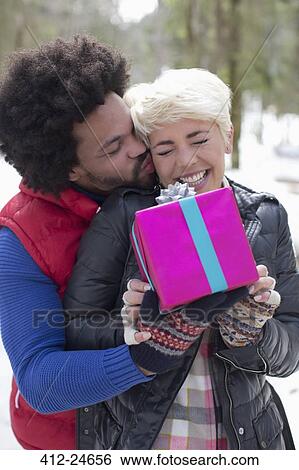 Stock Photograph - Couple with gift outdoors. Fotosearch