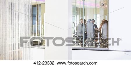 Stock Image - Distant view of business people having meeting in conference room. Fotosearch