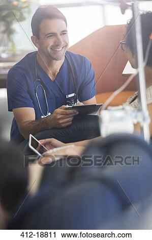 Doctor holding digital tablet, talking to patient undergoing medical treatment in outpatient clinic View Large Photo Image Stock Image - Doctor holding digital tablet, talking to patient undergoing medical treatment in outpatient clinic. Fotosearch
