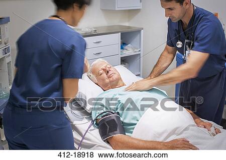 Doctor performing CPR on unconscious patient in emergency room View Large Photo Image Stock Photo - Doctor performing CPR on unconscious patient in emergency room. Fotosearch