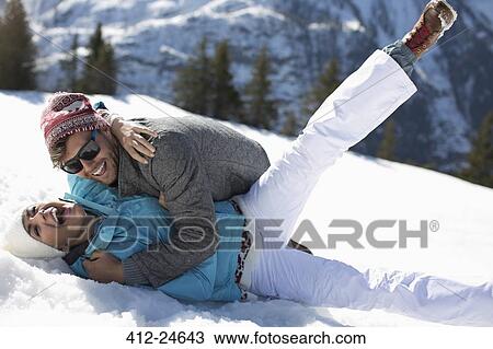 Exuberant couple laying in snow View Large Photo Image Stock Image - Exuberant couple laying in snow. Fotosearch