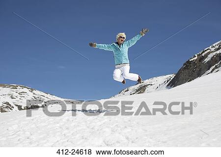 Exuberant woman jumping in snow View Large Photo Image Stock Photo - Exuberant woman jumping in snow. Fotosearch