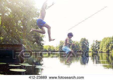 Father and son jumping into lake View Large Photo Image Stock Photo - Father and son jumping into lake. Fotosearch