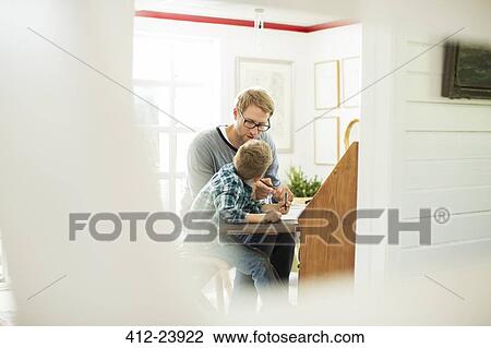 Father and son talking at table View Large Photo Image Stock Image - Father and son talking at table. Fotosearch