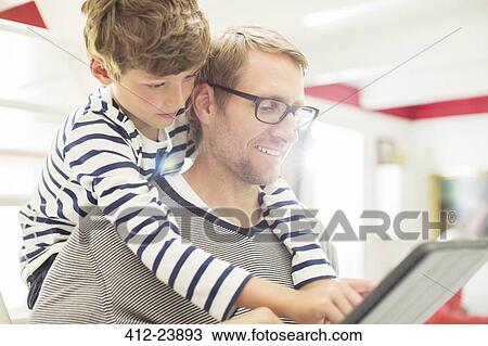 Stock Image - Father and son using digital tablet. Fotosearch