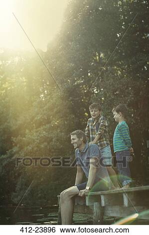 Father and sons relaxing at lake View Large Photo Image Stock Photograph - Father and sons relaxing at lake. Fotosearch
