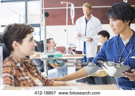 Female doctor holding clip board checking with female patient in outpatient clinic View Large Photo Image Stock Photo - Female doctor holding clip board checking with female patient in outpatient clinic. Fotosearch