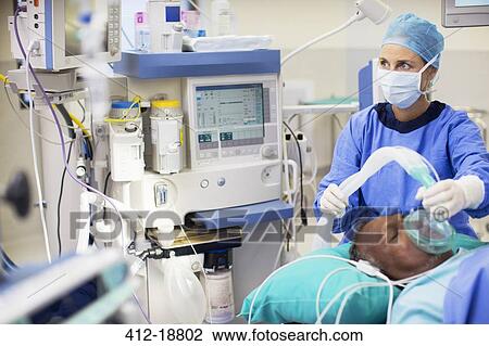 Female doctor wearing surgical clothing anesthetizing patient in operating theater View Large Photo Image Stock Image - Female doctor wearing surgical clothing anesthetizing patient in operating theater. Fotosearch