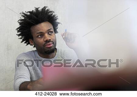 Focused university student listening during seminar in classroom View Large Photo Image Stock Photo - Focused university student listening during seminar in classroom. Fotosearch