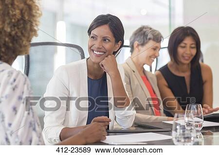 Four women sitting and talking at conference table View Large Photo Image Stock Photo - Four women sitting and talking at conference table. Fotosearch