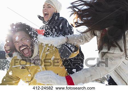Friends enjoying snowball fight View Large Photo Image Stock Image - Friends enjoying snowball fight. Fotosearch