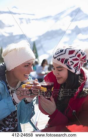 Friends in warm clothing drinking tea outdoors View Large Photo Image Stock Photo - Friends in warm clothing drinking tea outdoors. Fotosearch