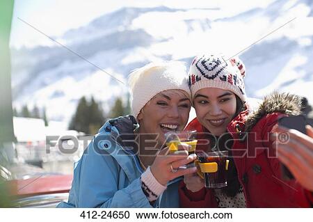 Friends in warm clothing taking selfie outdoors View Large Photo Image Stock Image - Friends in warm clothing taking selfie outdoors. Fotosearch