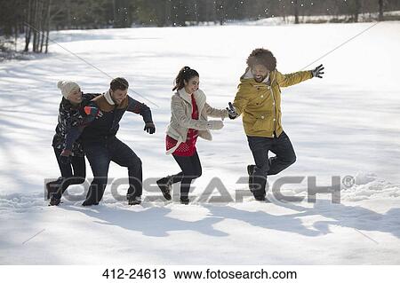 Stock Image - Friends playing in snow. Fotosearch
