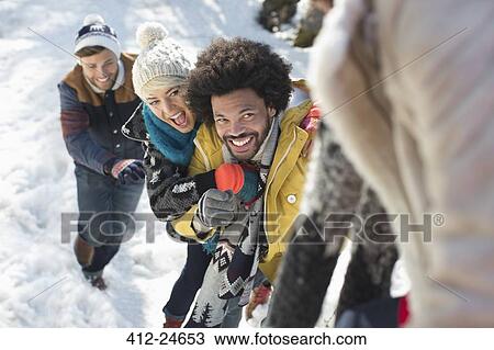 Stock Image - Friends playing in snow. Fotosearch