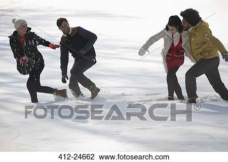 Stock Image - Friends playing in snow. Fotosearch