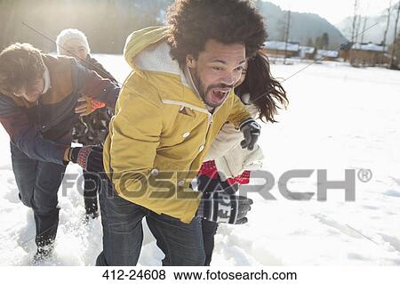 Stock Photo - Friends playing in snow. Fotosearch