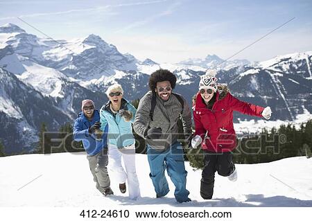 Stock Image - Friends running in snow. Fotosearch