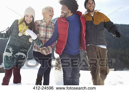 Stock Photograph - Friends running in snow. Fotosearch
