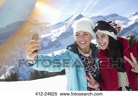 Stock Photography - Friends taking selfie in snow. Fotosearch
