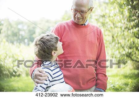 Stock Image - Grandfather and grandson hugging outdoors. Fotosearch