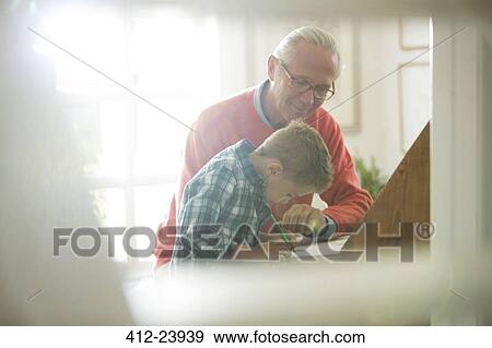 Grandfather and grandson writing at desk View Large Photo Image Stock Photo - Grandfather and grandson writing at desk. Fotosearch