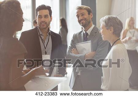 Group of business people smiling and discussing in office View Large Photo Image Stock Image - Group of business people smiling and discussing in office. Fotosearch