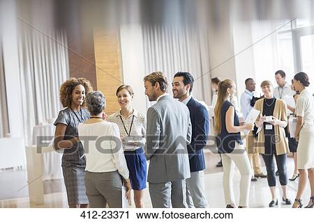 Group of business people standing in hall, smiling and talking together View Large Photo Image Stock Image - Group of business people standing in hall, smiling and talking together. Fotosearch